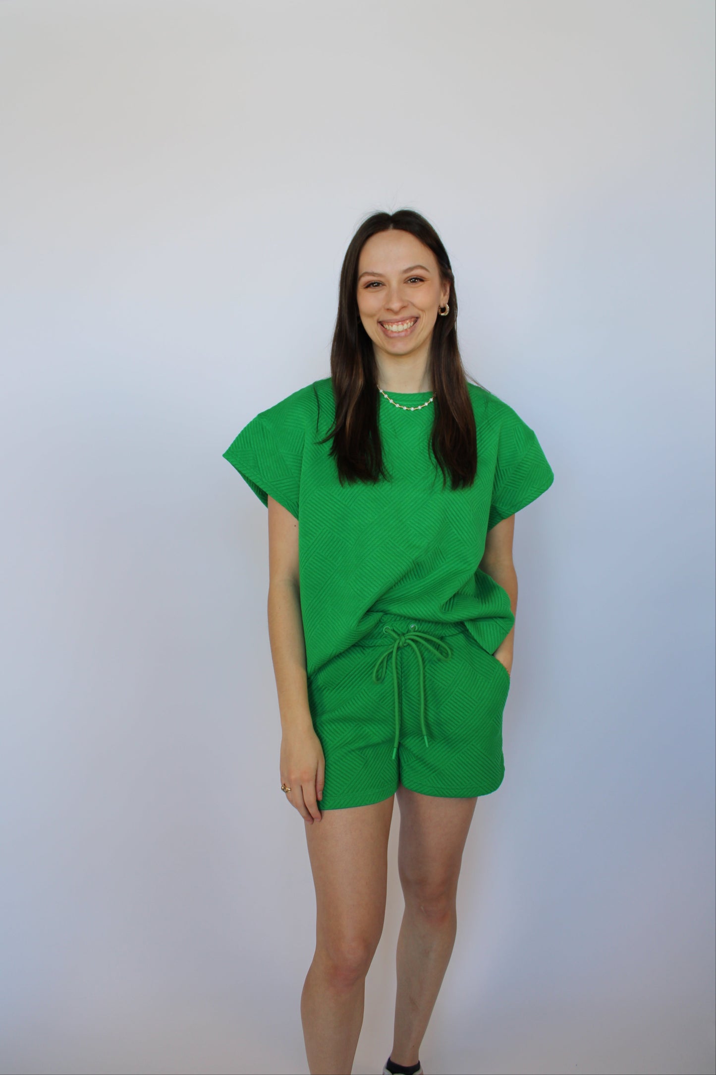 Woman wearing a green short set against a white background