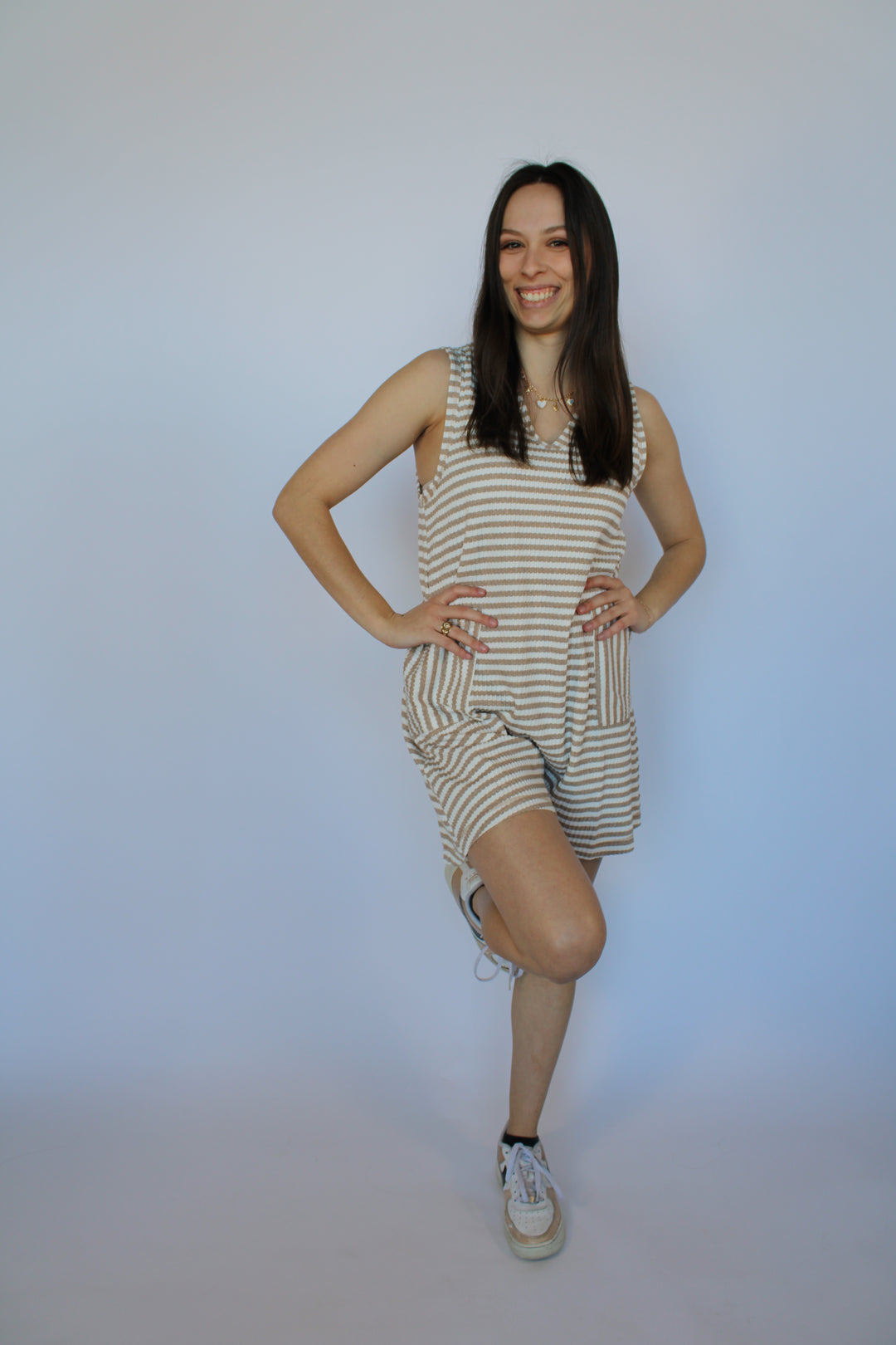 Woman in a striped dress standing on a white background