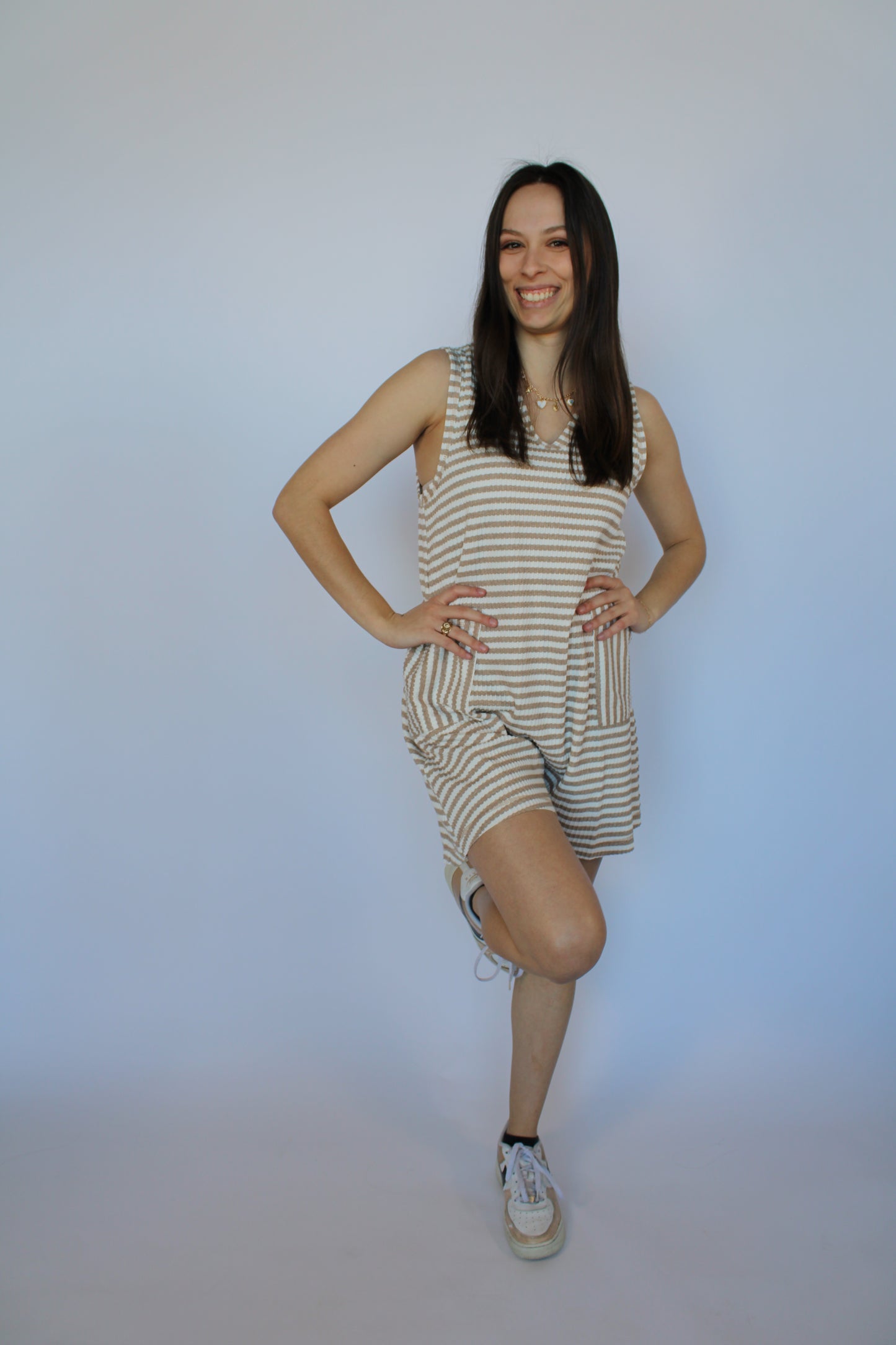 Woman in a striped dress standing on a white background