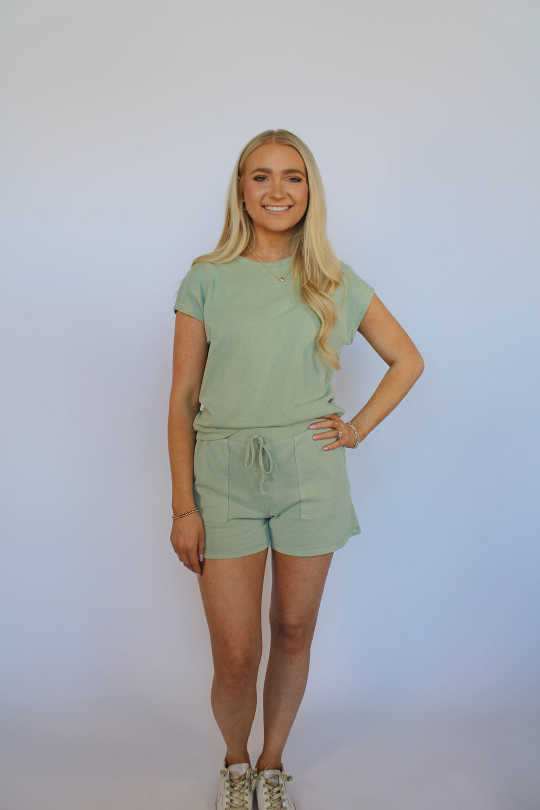 Woman in a light green set against a white background