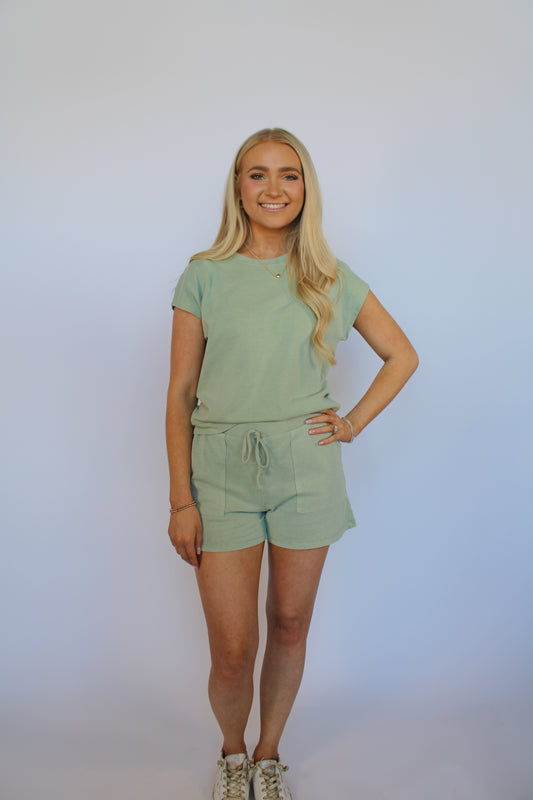 Woman in a light green set against a white background